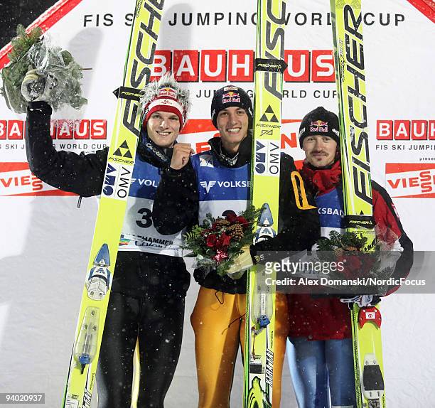 Winner Gregor Schlierenzauer of Austria poses on the Podium together with Thomas Morgenstern of Austria who placed second and Adam Malysz of Poland...