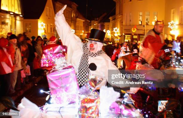 Woman dressed in a snow man outfit rides on her motor bike during the 11th Santa Clauses parade on December 5, 2009 in Brandenburg, near Berlin,...