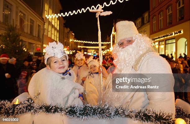 Man and a child dressed in Santa Claus outfits look on during the 11th Santa Clauses parade on December 5, 2009 in Brandenburg, near Berlin, Germany....