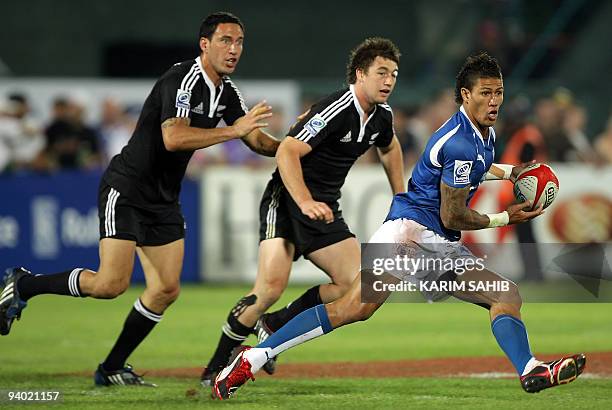 New Zealand's Zar Lawrence and Kurt Baker approach Samoa's Lolo Lui as he advances with the ball during their Dubai Sevens final rugby match in the...