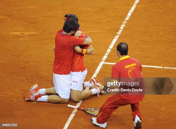 Feliciano Lopez and Fernando Verdasco of Spain embrace while team captain Albert Costa runs to congratulate them after they beat Radek Stepanek and...