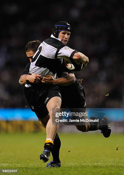 Matt Giteau of the Barbarians is tackled by Luke McAlister of New Zealand during the MasterCard Trophy match between Barbarians and New Zealand at...