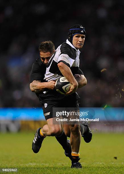 Matt Giteau of the Barbarians is tackled by Luke McAlister of New Zealand during the MasterCard Trophy match between Barbarians and New Zealand at...
