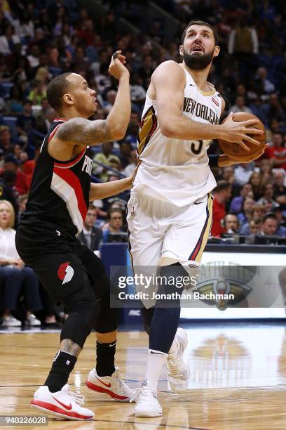 Nikola Mirotic of the New Orleans Pelicans drives against Shabazz Napier of the Portland Trail Blazers during the second half at the Smoothie King...