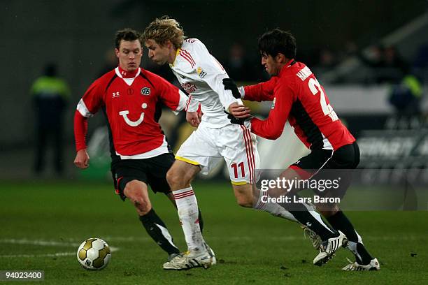 Stefan Kiessling of Leverkusen is challenged by Hanno Balitsch and Karim Haggui of Hannover during the Bundesliga match between Hannover 96 and Bayer...