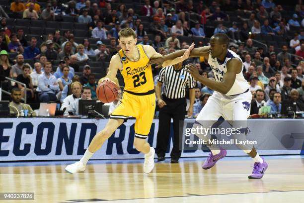 Max Curran of the UMBC Retrievers dribbles by Makol Mawien of the Kansas State Wildcats during the second round of the 2018 NCAA Men's Basketball...