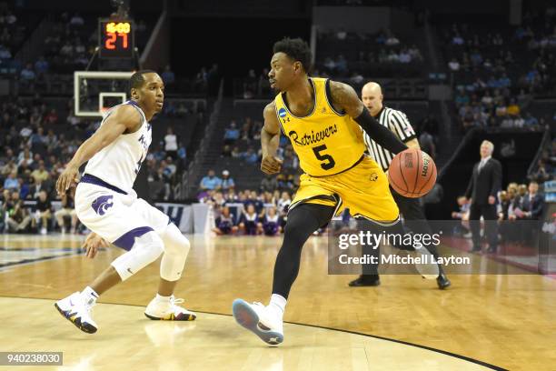 Jourdan Grant of the UMBC Retrievers dribbles around Barry Brown Jr. #5 of the Kansas State Wildcats during the second round of the 2018 NCAA Men's...