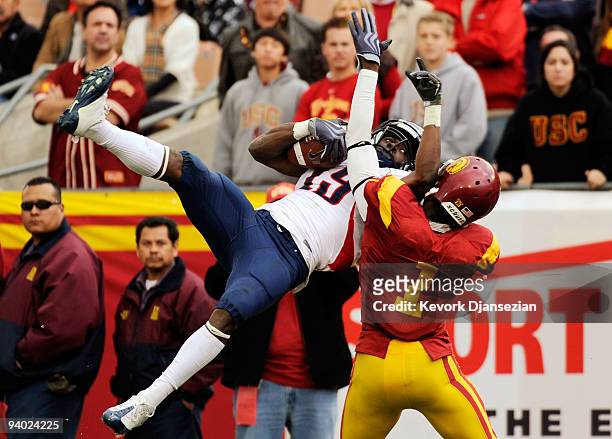 Wide receiver William Wright of the Arizona Wildcats catches a pass for a 19-yard gain against corner back T.J. Bryant of the USC Trojans on the...