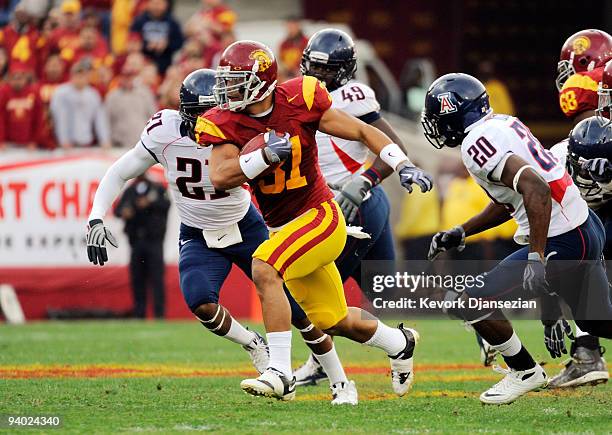 Fullback Stanley Havili of the USC Trojans breaks away from defenders Corey Hall and Cam Nelson of the Arizona Wildcats during the second quarter of...