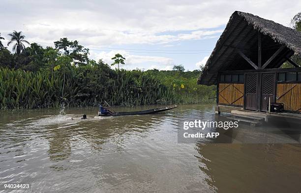 Peasant rows his boat next to his house, in an area flooded by the Chipiriri River on December 5, 2009 in Puerto San Francisco, Cochabamba...