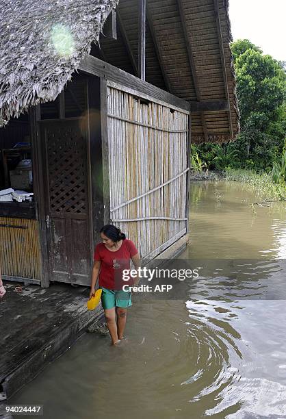 Woman walks next to her house, in an area flooded by the Chipiriri River on December 5, 2009 in Puerto San Francisco, Cochabamba departmment, 590 km...