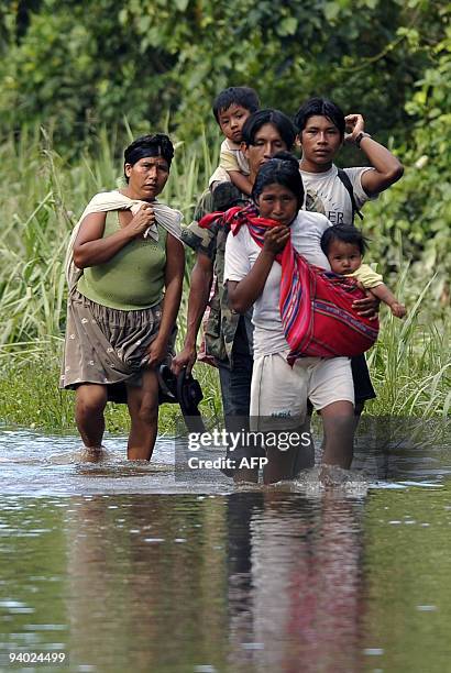 Peasant family walks along the road that links Puerto San Francisco and Villa 14 de Septiembre, in an area flooded by the Chipiriri River in...