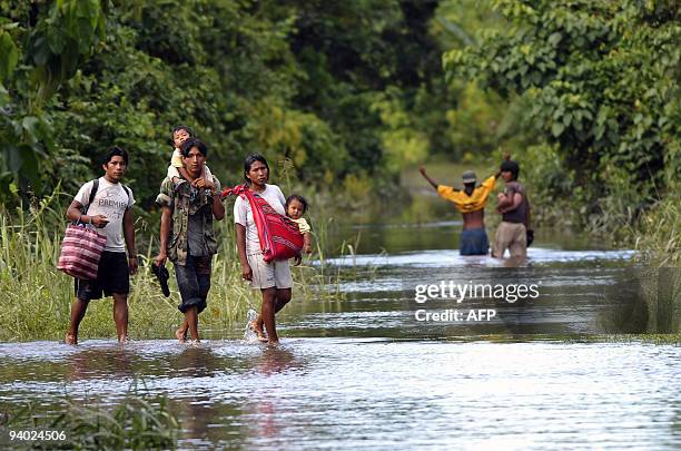 Peasant family walks along the road that links Puerto San Francisco and Villa 14 de Septiembre, in an area flooded by the Chipiriri River in...