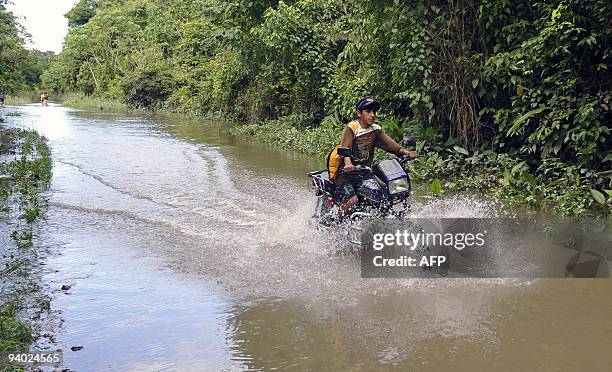 Motorcyclist rides along the road that links Puerto San Francisco and Villa 14 de Septiembre, in an area flooded by the Chipiriri River in Cochabamba...