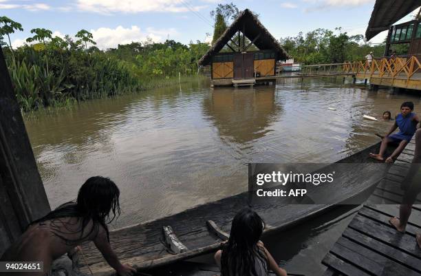 Kids play with a boat at their yard flooded by the Chipiriri River on December 5, 2009 in Puerto San Francisco, Cochabamba departmment, 590 km...