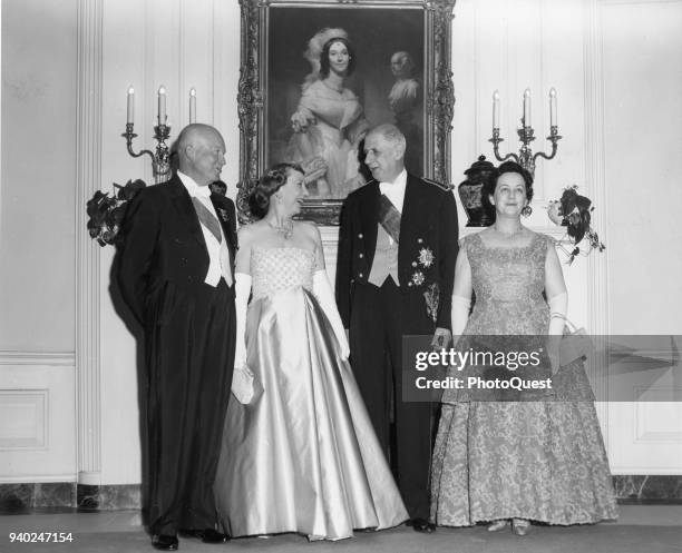 Portrait of, from left, American politician US President Dwight D Eisenhower and his wife, First Lady Mamie Eisenhower , and Frence President Charles...