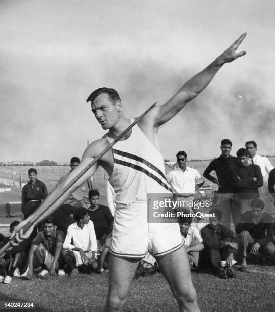 American Olympic decathlete Bob Mathias demonstrates the javelin throw for athletes at the Vallabhbhai Patel Stadium during a good will tour, Bombay,...