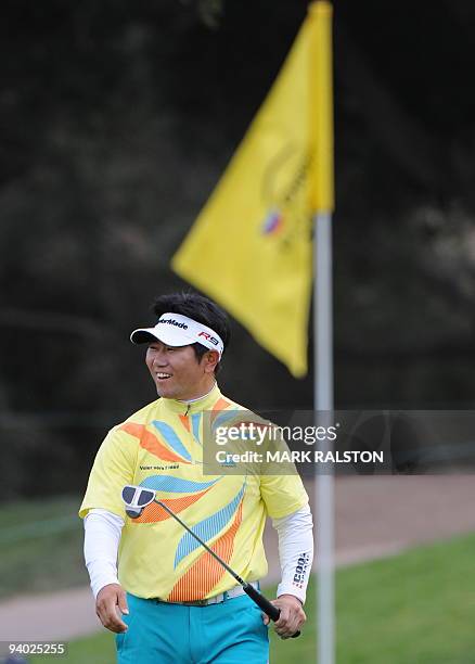 Yang Yong-Eun of Korea smiles after sinking his putt on the 18th hole at the Sherwood Country Club before finishing day three in the equal lead at 10...