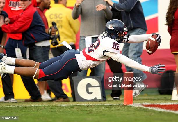 Wide receiver Juron Criner of the Arizona Wildcats dives into the end zone with a 36 yard catch for the winning touchdown in the fourth quarter...