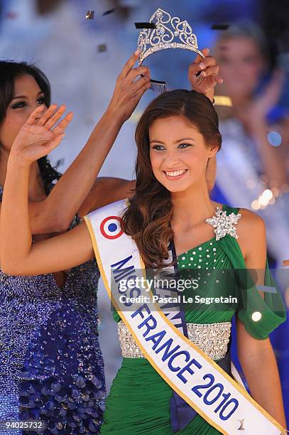 Miss Normandie Malika Menard receives the crown from 2009 Miss France Chloe Mortaud during the 2010 Miss France Beauty pageant at Palais Nikaia on...