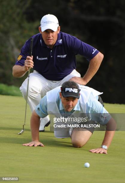World number four Lee Westwood of England is helped by his caddy to line up a shot on the 18th hole at the Sherwood Country Club on day three of the...