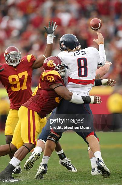 Quarterback Nick Foles of the Arizona Wildcats is hit as he throws a pass by defensive end Everson Griffen of the USC Trojans on December 5, 2009 at...