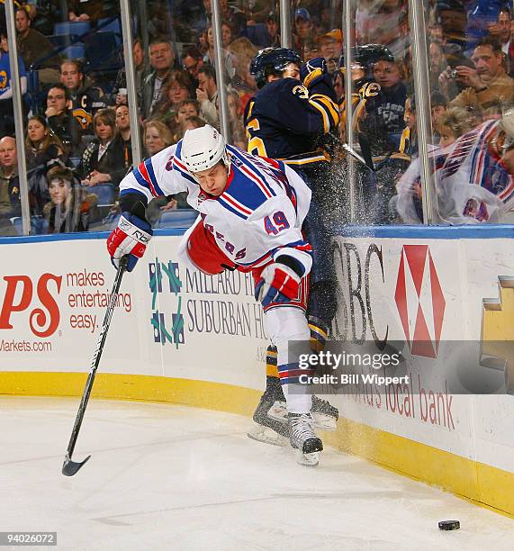 Patrick Kaleta of the Buffalo Sabres get checked into the endboards by Ilkka Heikkinen of the New York Rangers on December 5, 2009 at HSBC Arena in...