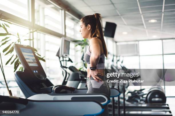 exhausted young woman after a treadmill run - tapete rolante aparelho de musculação imagens e fotografias de stock