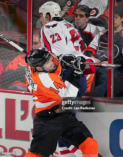 Ian Laperriere of the Philadelphia Flyers checks Milan Jurcina of the Washington Capitals into the boards on December 5, 2009 at the Wachovia Center...