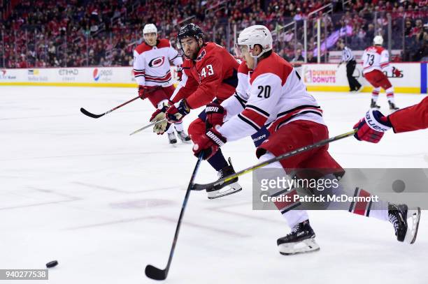 Tom Wilson of the Washington Capitals and Sebastian Aho of the Carolina Hurricanes battle for the puck in the first period at Capital One Arena on...