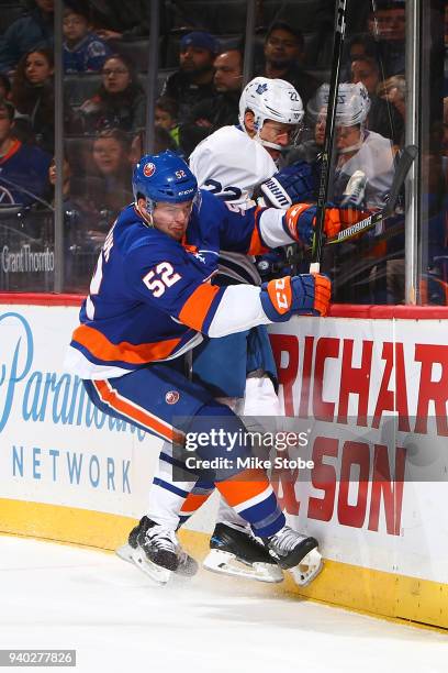 Ross Johnston of the New York Islanders checks Nikita Zaitsev of the Toronto Maple Leafs into the boards at Barclays Center on March 30, 2018 in New...