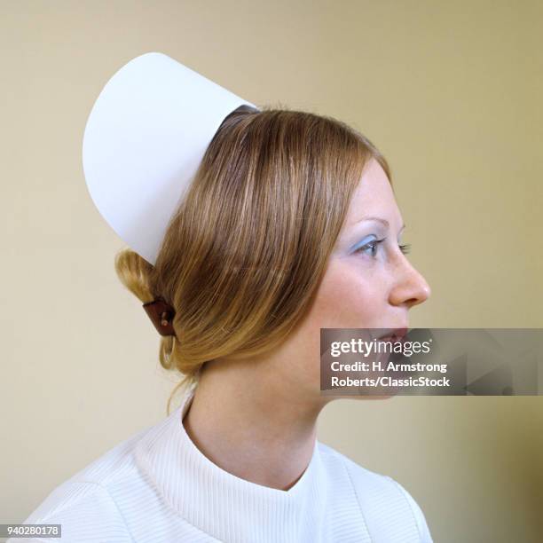 1970s PROFILE PORTRAIT REGISTERED NURSE WEARING CAP AND SLEEK HAIRSTYLE