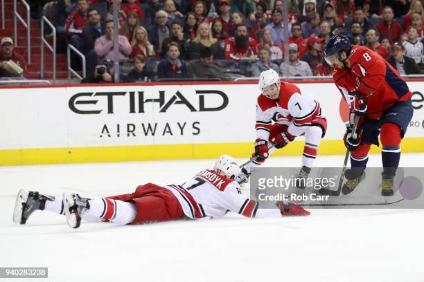 Trevor van Riemsdyk and Derek Ryan of the Carolina Hurricanes go after the puck against Alex Ovechkin of the Washington Capitals in the second period...