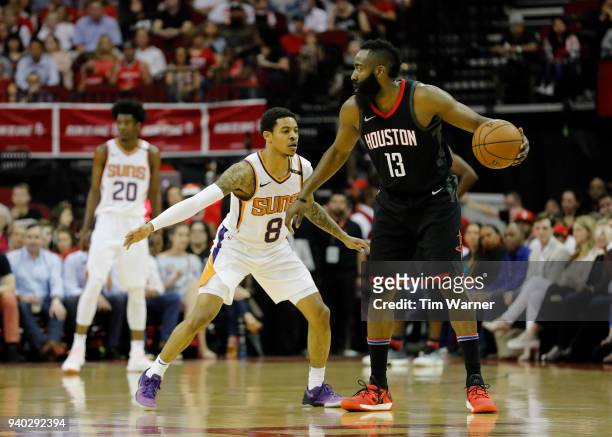 James Harden of the Houston Rockets controls the ball defended by Tyler Ulis of the Phoenix Suns in the first half at Toyota Center on March 30, 2018...