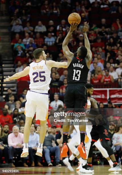 James Harden of the Houston Rockets takes a three point shot defended by Alec Peters of the Phoenix Suns in the first half at Toyota Center on March...