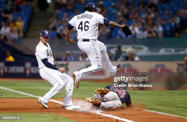 Eduardo Nunez of the Boston Red Sox reaches first base on an infield single as pitcher Jose Alvarado of the Tampa Bay Rays leaps over him during the...