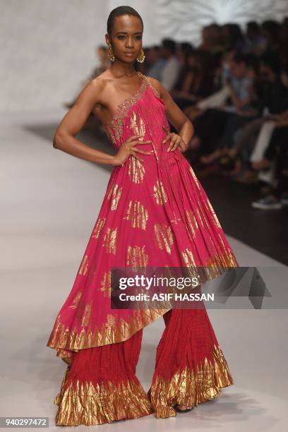 Model presents a creation by Pakistani designer Umar Sayeed on the final day of the 'Hum Showcase' Fashion Week in Karachi on late March 30, 2018. /...