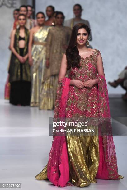 Pakistani actress and model Mahira Khan presents a creation by Pakistani designer Umar Sayeed on the final day of the 'Hum Showcase' Fashion Week in...