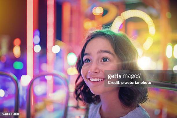 chica feliz sonríe en noria en un parque de diversiones - imponente fotografías e imágenes de stock