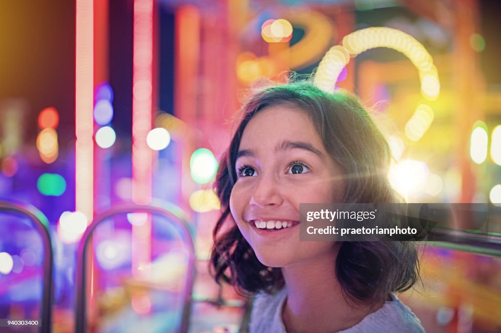 Happy girl is smiling on ferris wheel in an amusement park