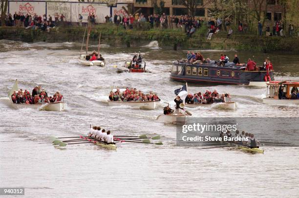 Entourage follow as Oxford pull away to victory during the 148th University Boat Race 2002 between Oxford University and Cambridge University held on...