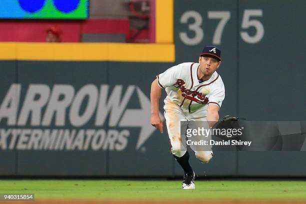 Peter Bourjos of the Atlanta Braves makes a diving catch during the ninth inning against the Philadelphia Phillies at SunTrust Park on March 30, 2018...