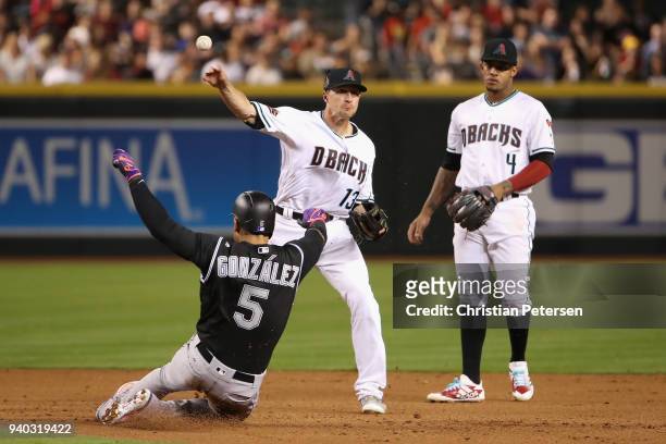 Infielder Nick Ahmed of the Arizona Diamondbacks throws over the sliding Carlos Gonzalez of the Colorado Rockies to complete a double play during the...