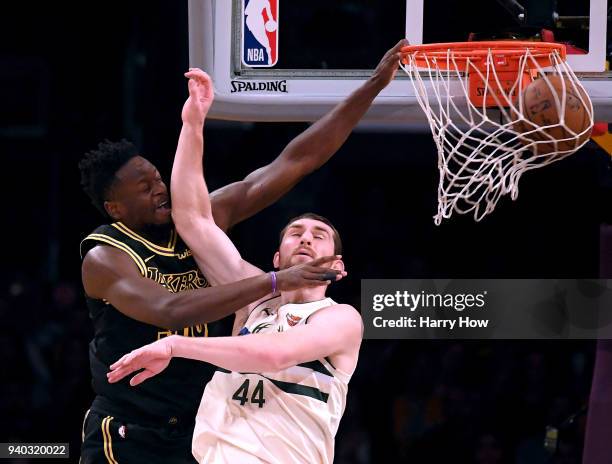 Julius Randle of the Los Angeles Lakers dunks over Tyler Zeller of the Milwaukee Bucks during the first half at Staples Center on March 30, 2018 in...