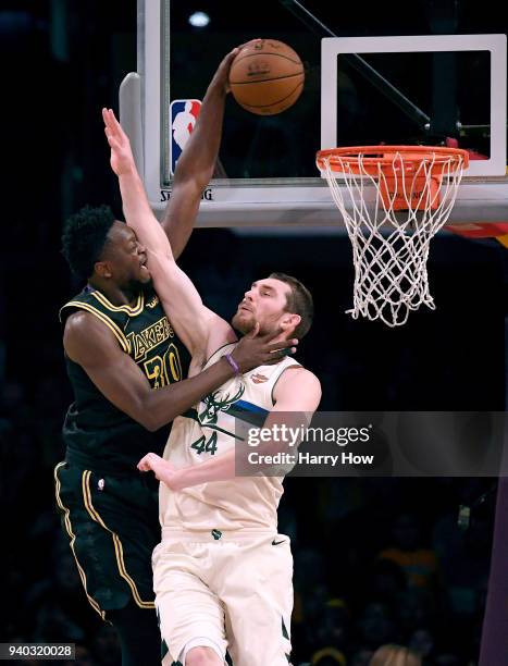 Julius Randle of the Los Angeles Lakers dunks over Tyler Zeller of the Milwaukee Bucks during the first half at Staples Center on March 30, 2018 in...