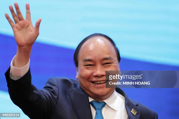 Vietnam's Prime Minister Nguyen Xuan Phuc waves during a group photo at the Greater Mekong Subregion Summit in Hanoi on March 31, 2018. / AFP PHOTO /...