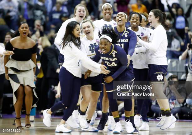 Arike Ogunbowale of the Notre Dame Fighting Irish is congratulated by her teammates after hitting the game winning basket to defeat the Connecticut...