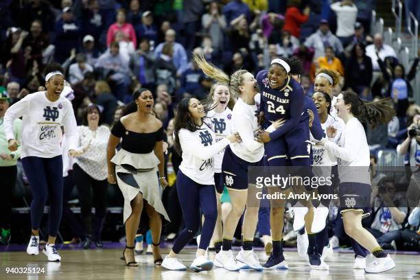 Arike Ogunbowale of the Notre Dame Fighting Irish is congratulated by her teammates after hitting the game winning basket to defeat the Connecticut...