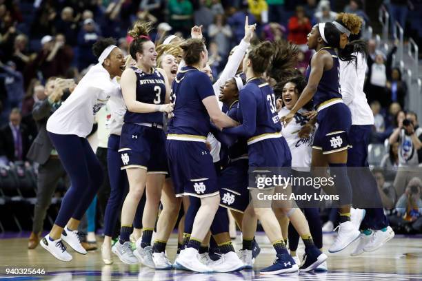 Arike Ogunbowale of the Notre Dame Fighting Irish is congratulated by her teammates after hitting the game winning basket to defeat the Connecticut...