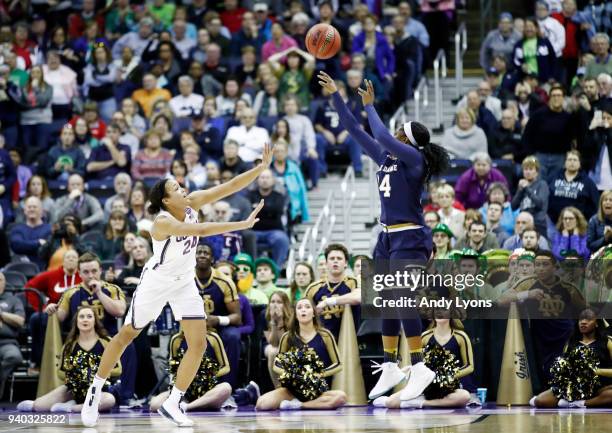 Arike Ogunbowale of the Notre Dame Fighting Irish hits the game winning shot with 1 second left in overtime under pressure from Napheesa Collier of...